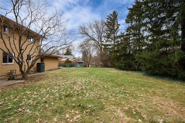 view of yard featuring fence and central AC