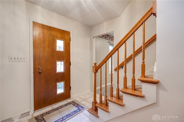 foyer entrance with stairs and visible vents