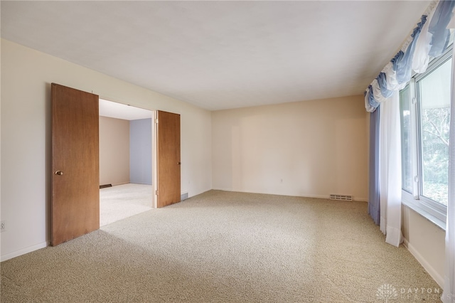 spare room featuring visible vents and carpet flooring