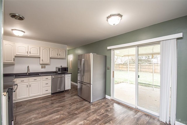 kitchen featuring sink, dark wood-type flooring, stainless steel appliances, and white cabinets