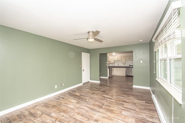 unfurnished living room featuring ceiling fan and hardwood / wood-style floors