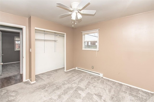 unfurnished bedroom featuring a baseboard heating unit, light colored carpet, a closet, and ceiling fan