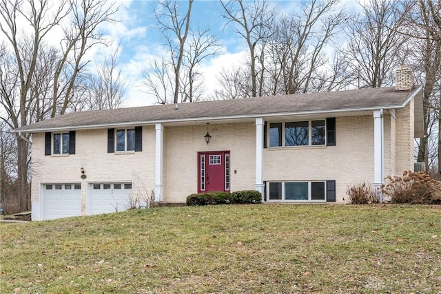 split foyer home with a garage and a front yard