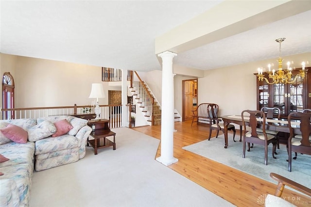 living room with hardwood / wood-style flooring, a chandelier, and decorative columns