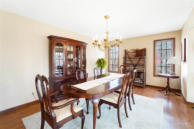 dining area featuring plenty of natural light, hardwood / wood-style floors, and a notable chandelier