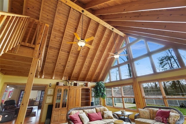 living room with ceiling fan, high vaulted ceiling, wooden ceiling, and beam ceiling