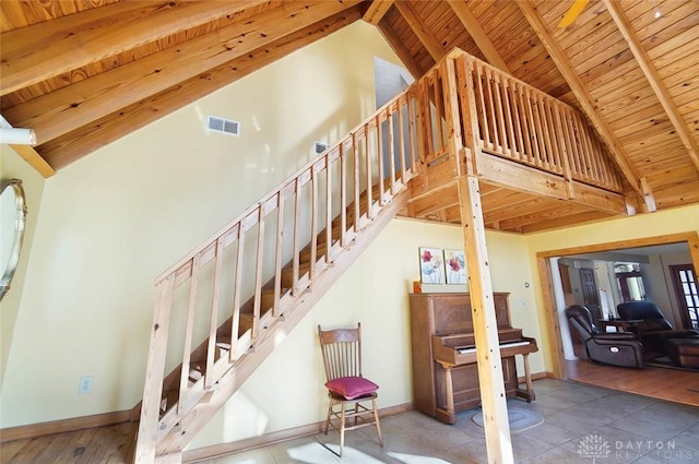 staircase with beam ceiling, high vaulted ceiling, and wood ceiling