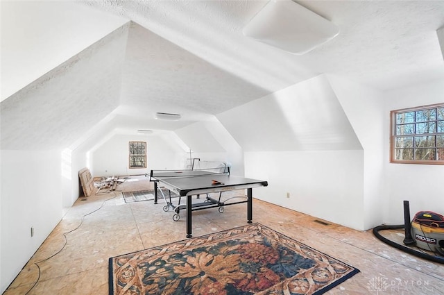 game room with lofted ceiling and a textured ceiling