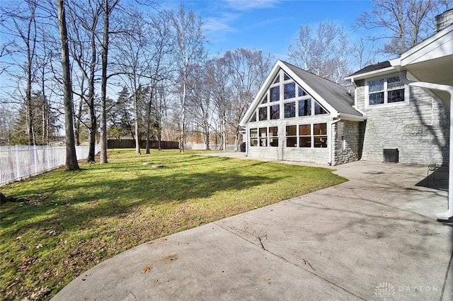 back of house with a patio and a lawn