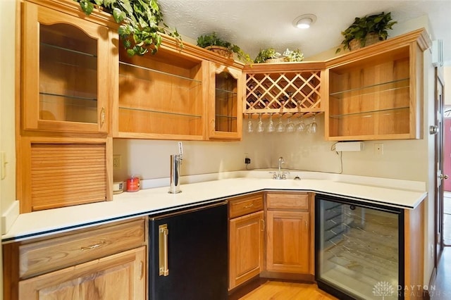 kitchen with wine cooler, high end fridge, sink, and light wood-type flooring