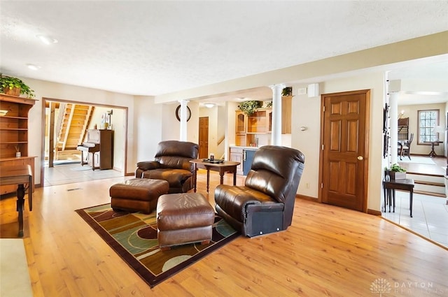 living room featuring light hardwood / wood-style flooring and ornate columns