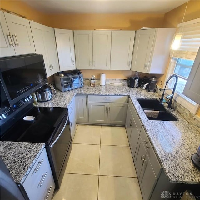 kitchen featuring sink, decorative light fixtures, black electric range, and white cabinets