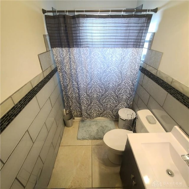 bathroom featuring tile walls, vanity, tile patterned floors, and toilet