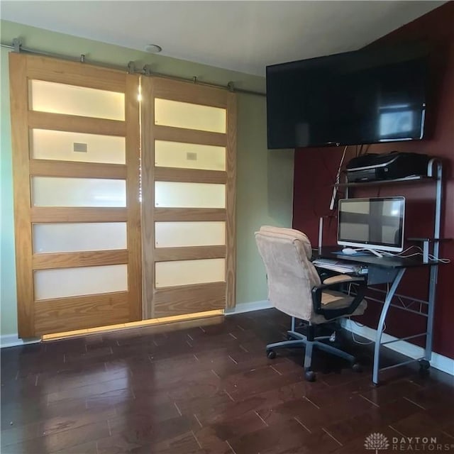 office space with a barn door and dark hardwood / wood-style flooring