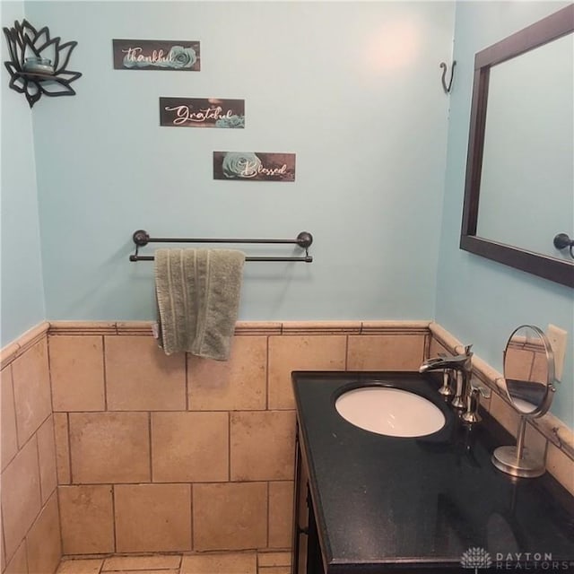 bathroom with vanity and tile walls