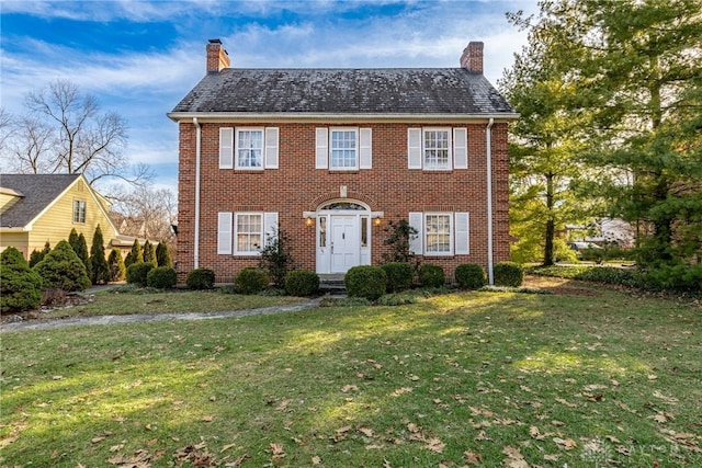 colonial inspired home featuring a front lawn