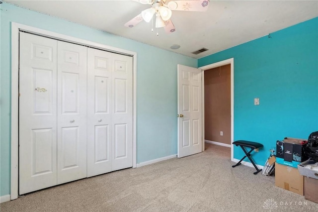 interior space with light carpet, ceiling fan, and a closet