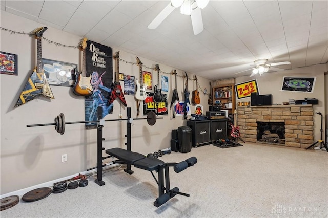 workout room featuring ceiling fan, a fireplace, and carpet