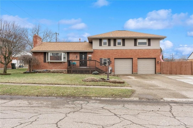 split level home with a garage, a front lawn, and a deck