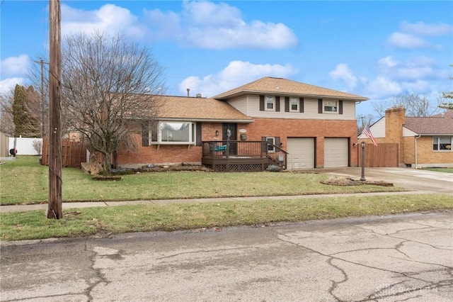 split level home featuring a garage, a front yard, and a deck