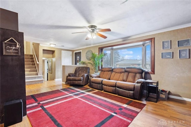 living room featuring hardwood / wood-style floors, crown molding, and ceiling fan