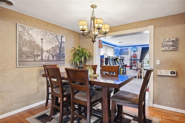 dining space with a notable chandelier and hardwood / wood-style flooring