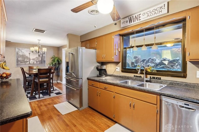 kitchen featuring sink, decorative light fixtures, light hardwood / wood-style floors, stainless steel appliances, and ceiling fan with notable chandelier