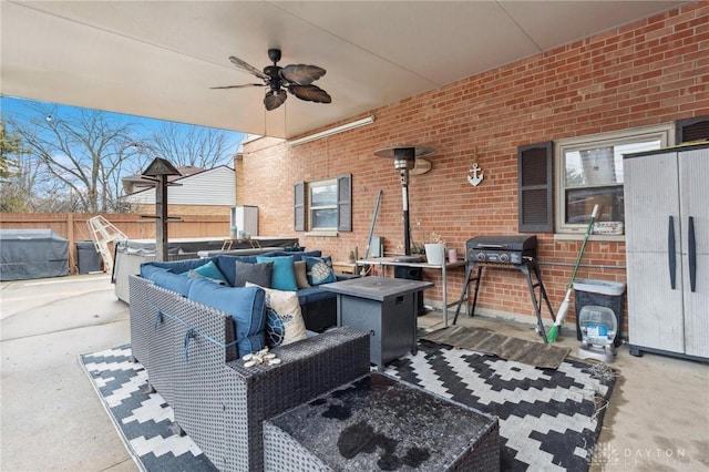 view of patio / terrace with ceiling fan, a jacuzzi, area for grilling, and an outdoor living space with a fire pit