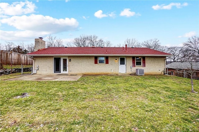 rear view of house with central AC unit, a yard, and a patio