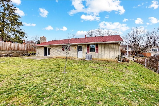 back of property with central AC unit, a yard, and a patio area