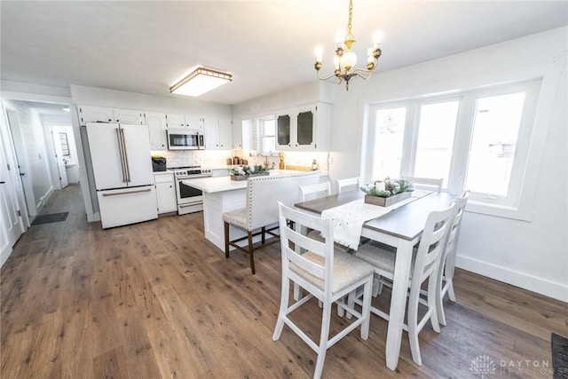 330 W Spring St, Eaton, OH 45320 - dining room with a chandelier, dark wood finished floors, and baseboards