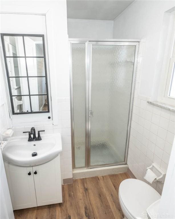 330 W Spring St, Eaton, OH 45320 - full bathroom featuring tile walls, vanity, a shower stall, wood finished floors, and toilet