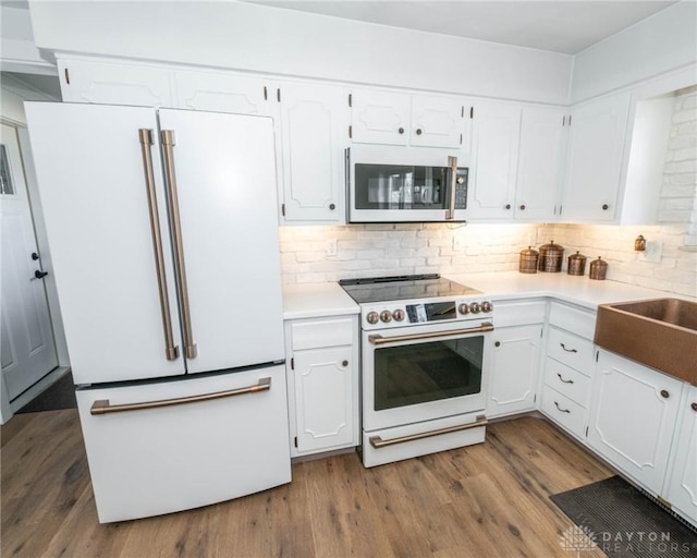 330 W Spring St, Eaton, OH 45320 - kitchen featuring white appliances, white cabinetry, dark wood finished floors, and decorative backsplash