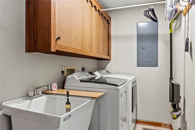 laundry room featuring cabinets, washing machine and clothes dryer, sink, and electric panel