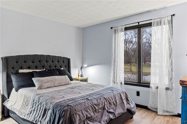 bedroom featuring multiple windows and light wood-type flooring