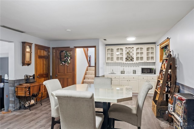 dining room with bar area and light wood-type flooring