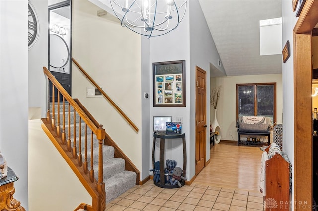 tiled entryway featuring lofted ceiling and a notable chandelier