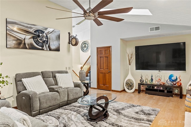 living room featuring vaulted ceiling, light hardwood / wood-style floors, and ceiling fan