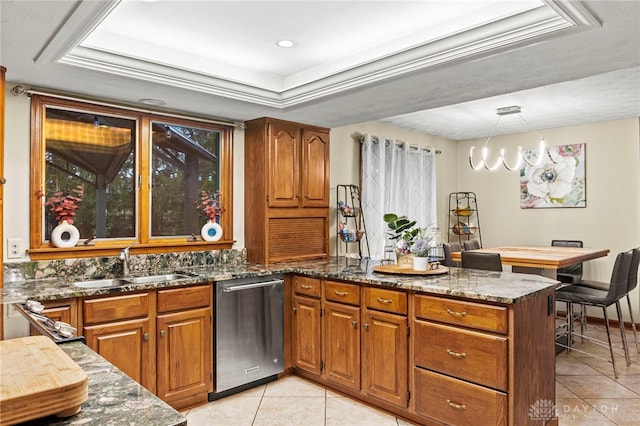 kitchen with decorative light fixtures, sink, dark stone countertops, stainless steel dishwasher, and light tile patterned floors