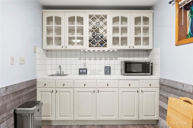 kitchen featuring sink, white cabinets, and backsplash