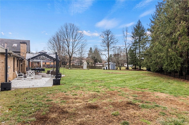 view of yard with a gazebo, a shed, and a patio area