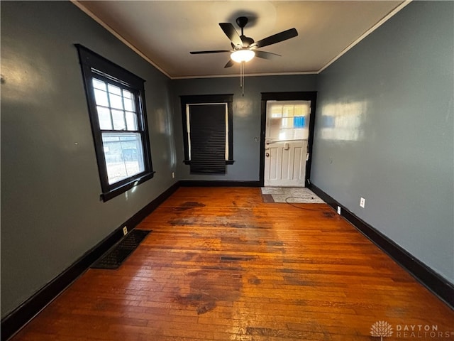 unfurnished room with crown molding, dark hardwood / wood-style floors, and ceiling fan