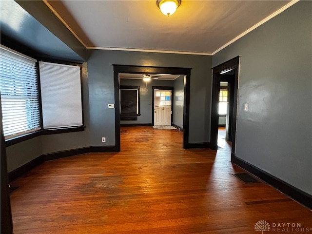 unfurnished room with dark wood-type flooring and ornamental molding