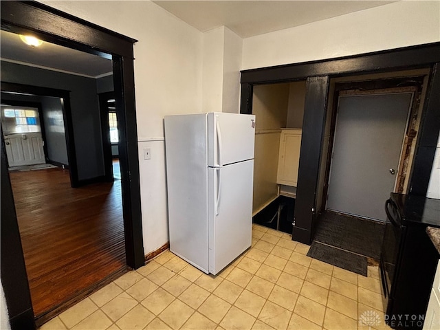 kitchen featuring light tile patterned flooring and white fridge