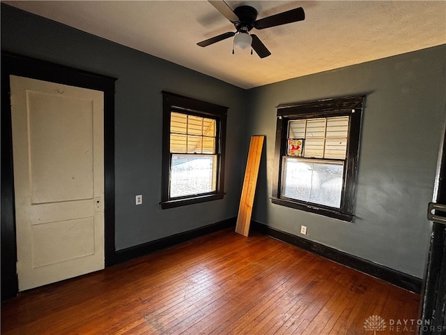 spare room with dark hardwood / wood-style floors and ceiling fan