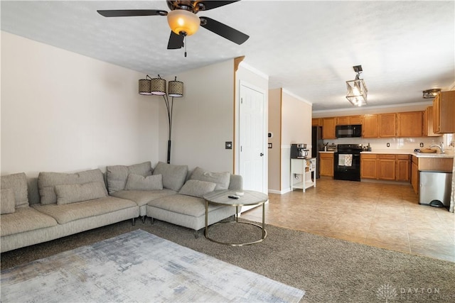 living room with sink, light tile patterned floors, ornamental molding, and ceiling fan