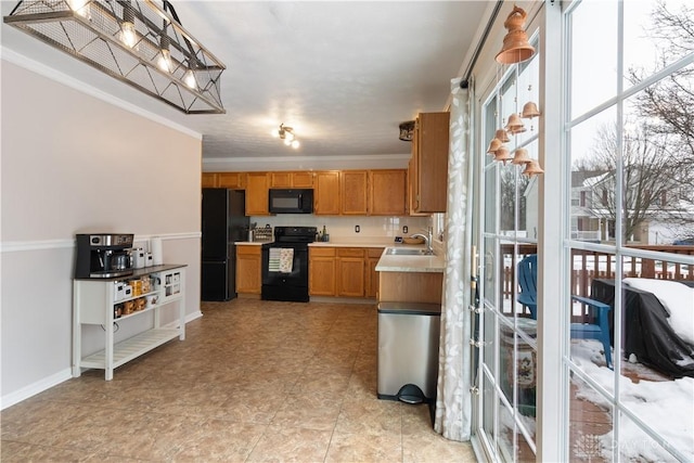 kitchen featuring crown molding, sink, and black appliances