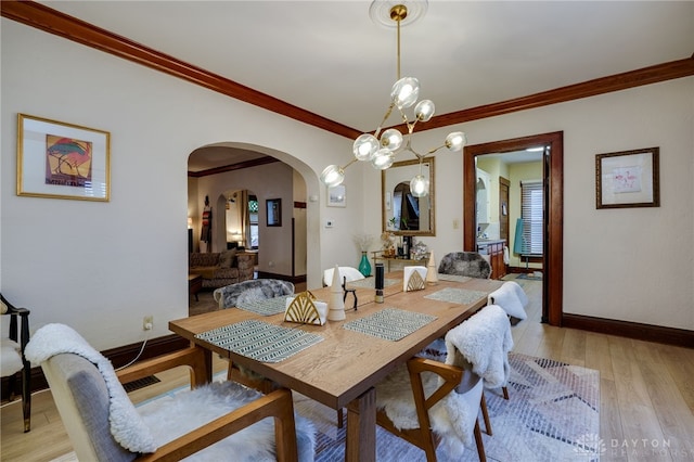 dining room featuring ornamental molding, a notable chandelier, and light wood-type flooring