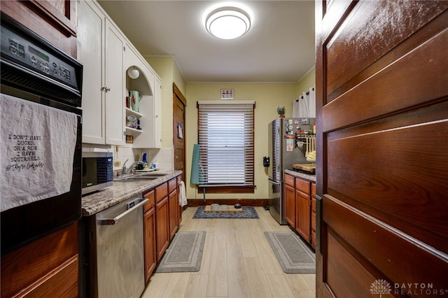 kitchen with sink, tasteful backsplash, crown molding, light hardwood / wood-style flooring, and appliances with stainless steel finishes