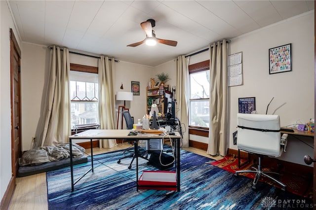 office with hardwood / wood-style flooring, ornamental molding, a healthy amount of sunlight, and ceiling fan